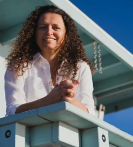 A woman standing on top of a white fence.