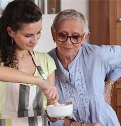 A woman and an old lady are cooking together.