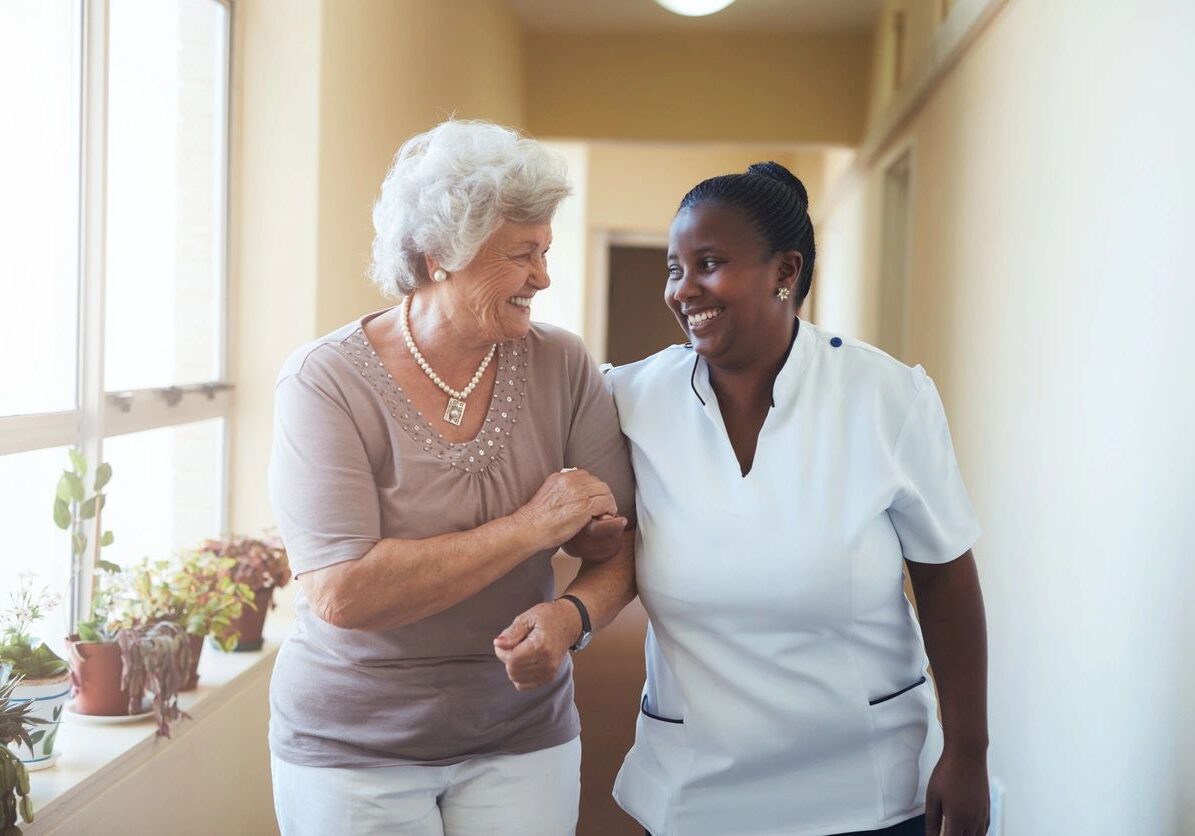 Two women are smiling and walking together.